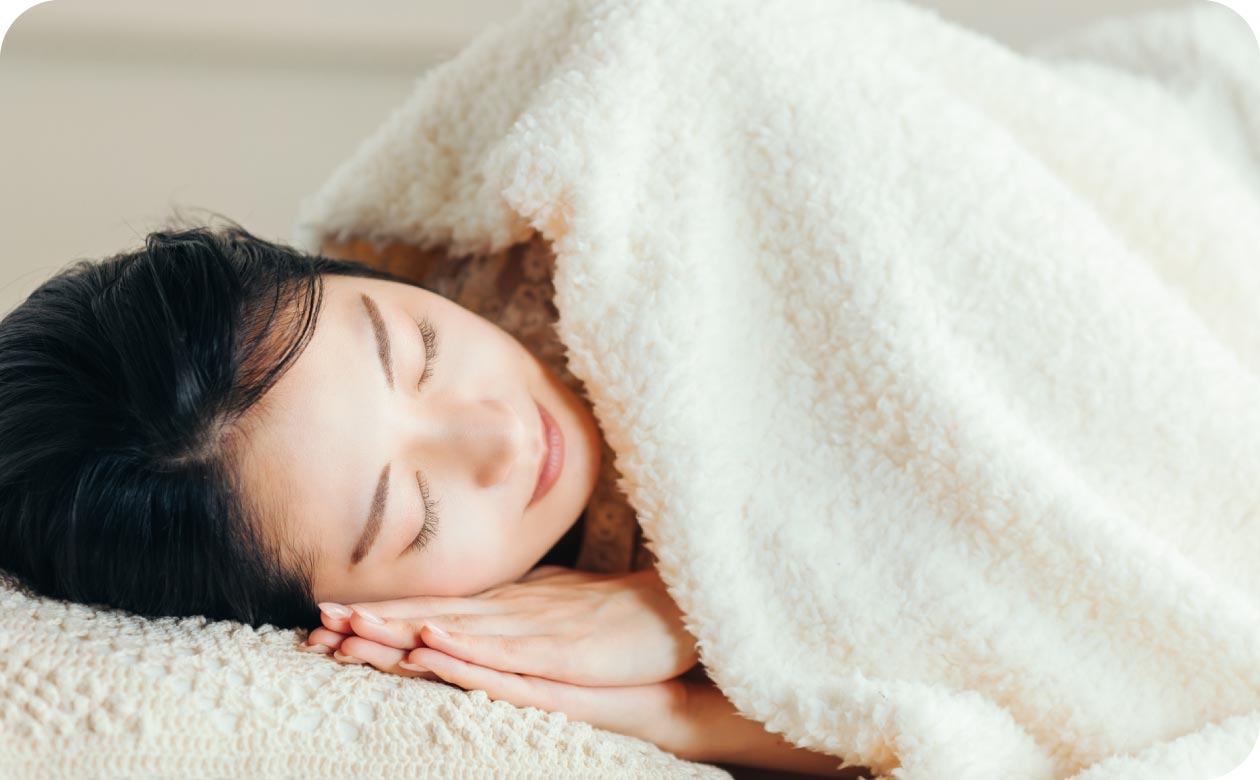 毛布にくるまって眠る女性