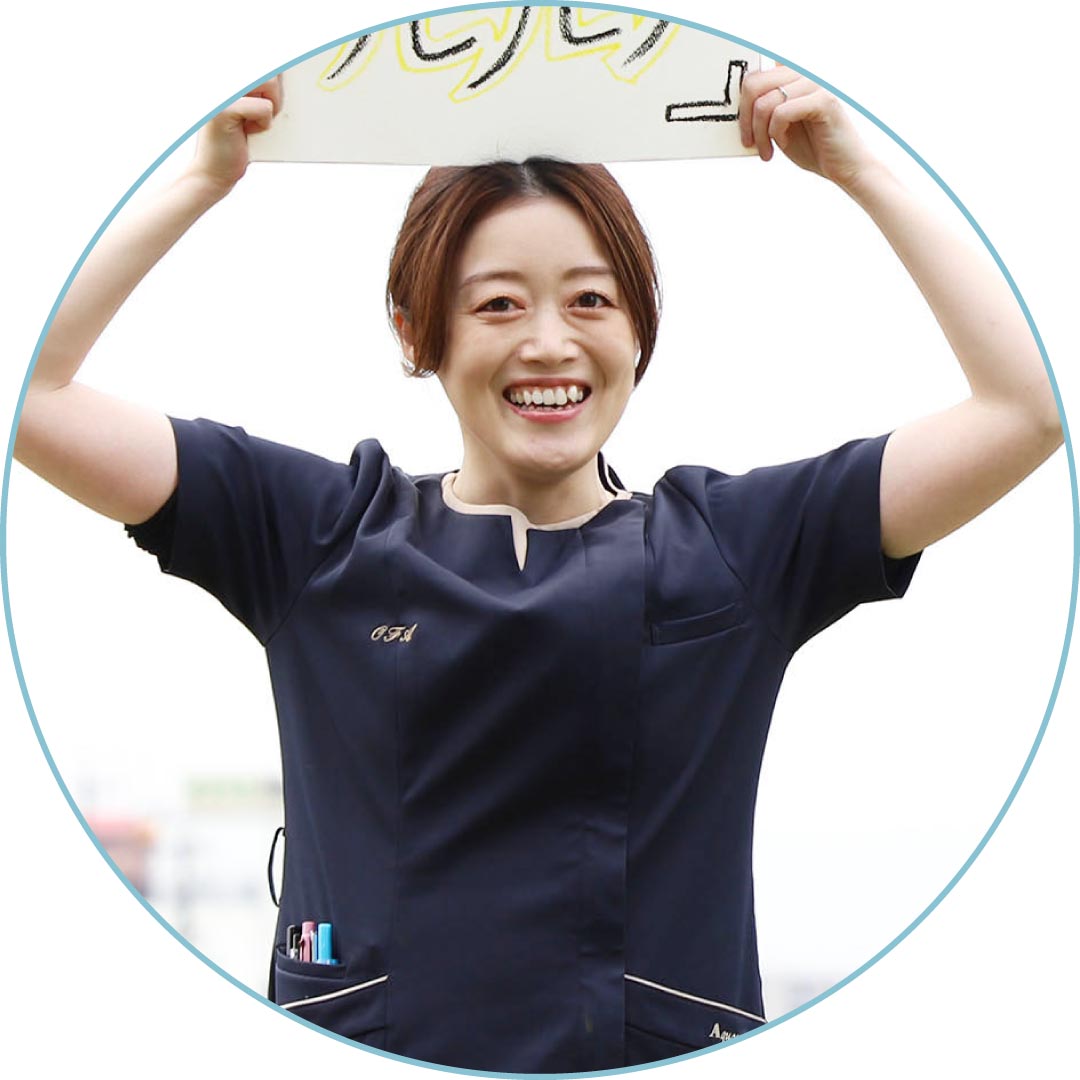 スケッチブックを掲げて笑うスタッフ