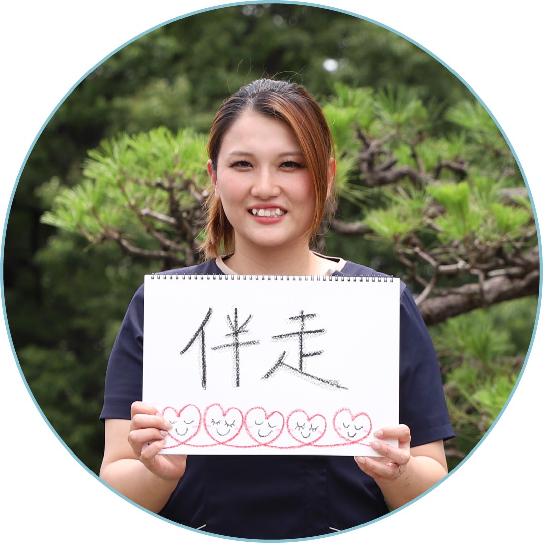 「伴走」と書いたスケッチブックを持つスタッフ