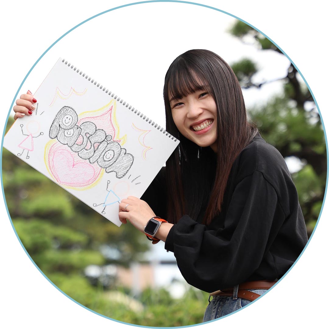 スケッチブックを持って笑うスタッフ